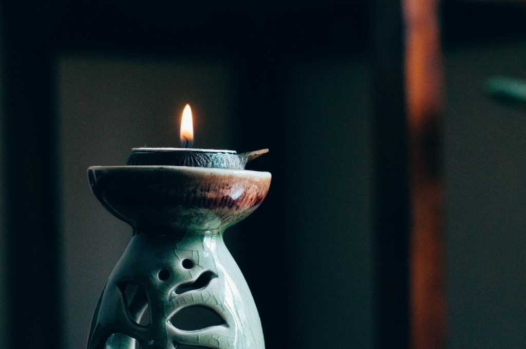 a candle sits on a ceramic stand