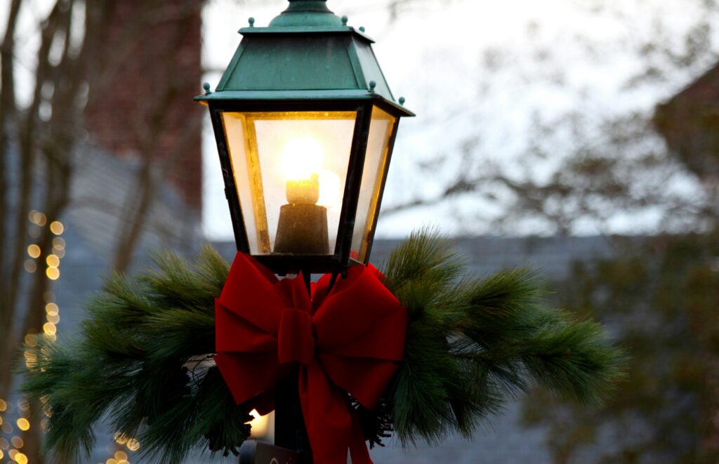 an old fashioned street lamp dressed with a bow and greens for christmas