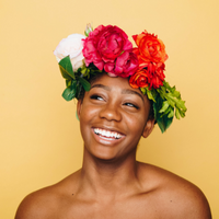 a black woman in a flower crown in front of a yellow background