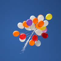 a bunch of colorful balloons floats into the sky