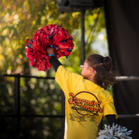 a child lifts a pompom into the air